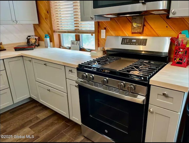 kitchen with gas stove, light countertops, and dark wood-style flooring