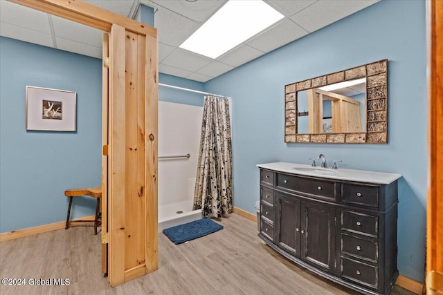 bathroom with a shower stall, wood finished floors, vanity, and baseboards
