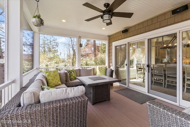sunroom / solarium with ceiling fan and an outdoor living space