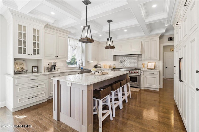kitchen with premium range hood, dark wood-style floors, a center island, a sink, and high end range