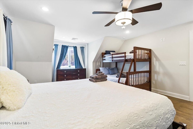 bedroom featuring visible vents, lofted ceiling, wood finished floors, baseboards, and a ceiling fan