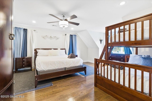 bedroom featuring visible vents, vaulted ceiling, wood finished floors, baseboards, and recessed lighting