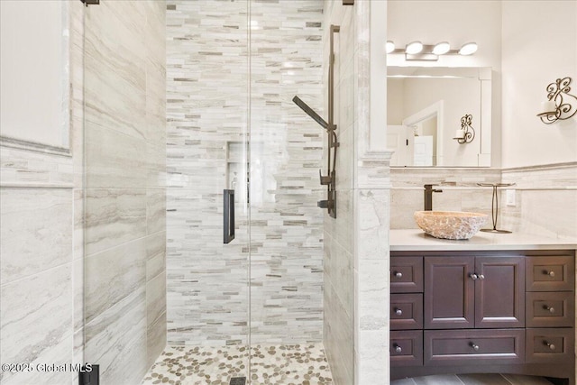 full bathroom with vanity, tile walls, and a stall shower