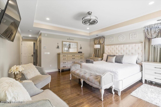 bedroom featuring baseboards, a tray ceiling, ornamental molding, and wood finished floors