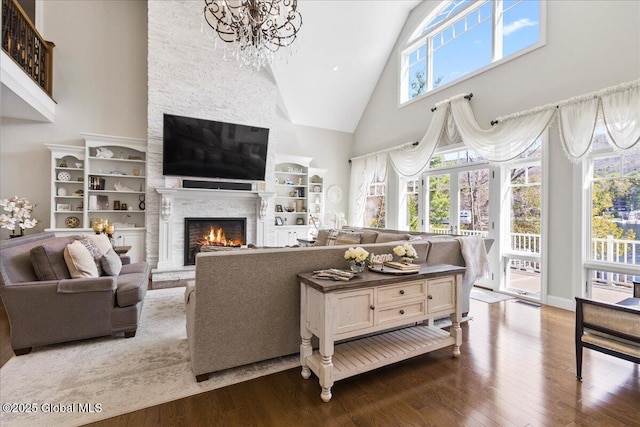 living room featuring an inviting chandelier, high vaulted ceiling, a fireplace, and dark wood-style floors