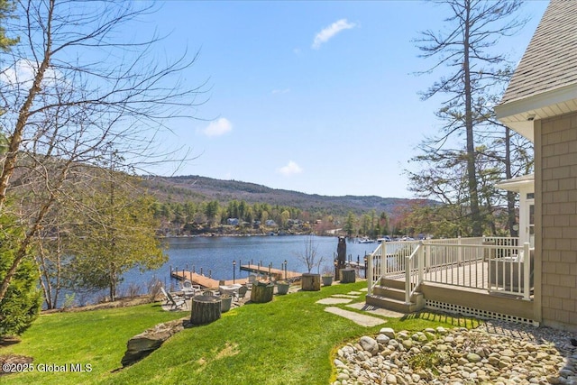 view of yard with a deck with water view