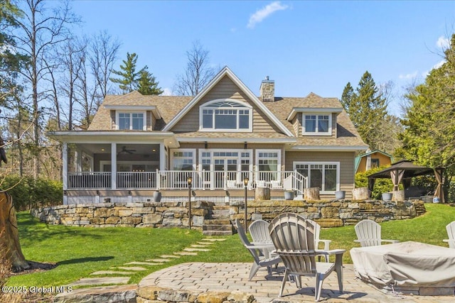 back of house featuring a lawn, a patio, a chimney, a ceiling fan, and a gazebo