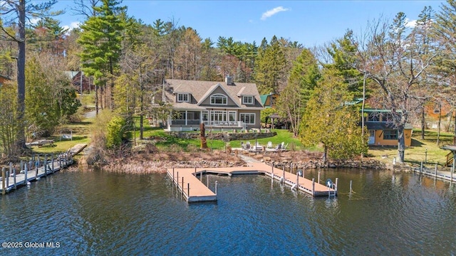 back of property featuring a lawn and a water view