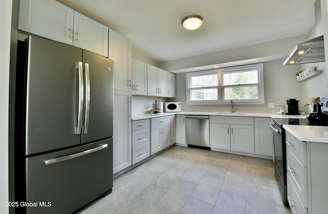 362 Lake Ave, Saratoga Springs, NY 12866 - kitchen with wall chimney range hood, appliances with stainless steel finishes, a sink, light tile patterned floors, and light countertops