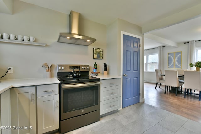 362 Lake Ave, Saratoga Springs, NY 12866 - kitchen with stainless steel range with electric cooktop, beam ceiling, light countertops, wall chimney exhaust hood, and light tile patterned floors