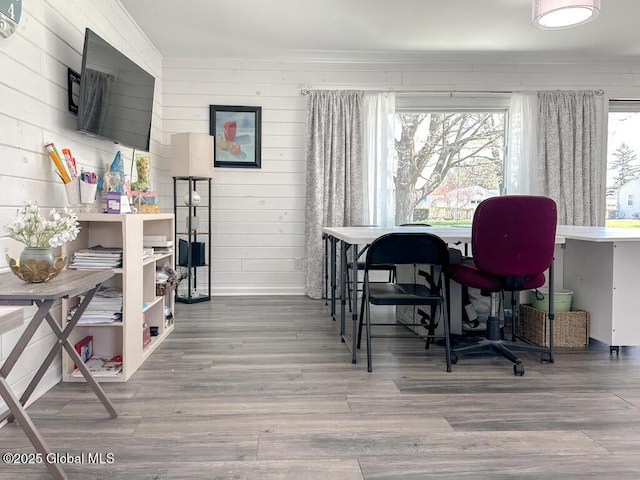 office area featuring wood walls, wood finished floors, and baseboards