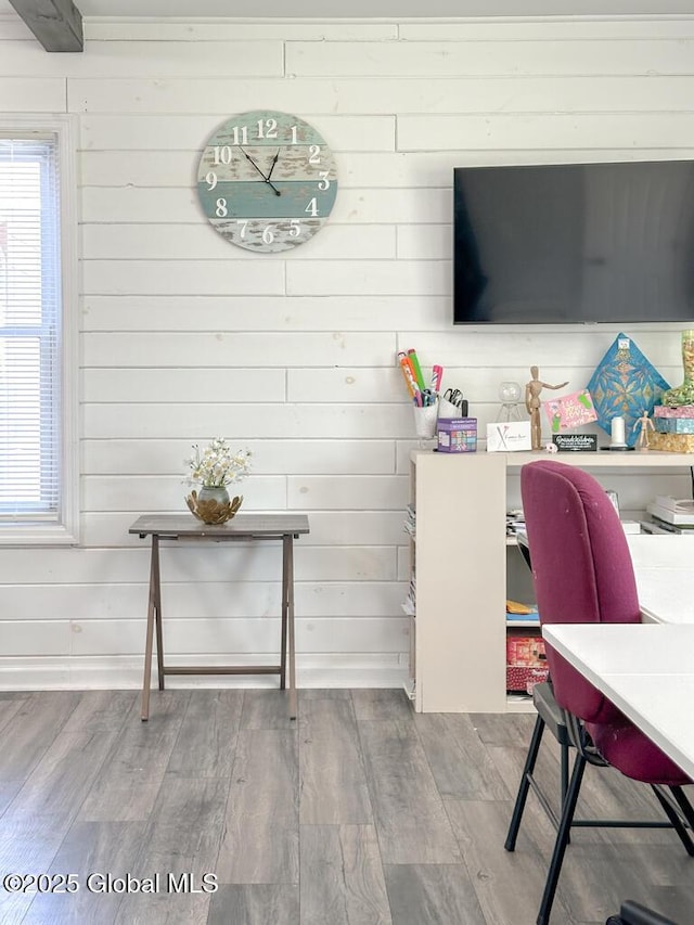 interior space with wood finished floors, wooden walls, and plenty of natural light