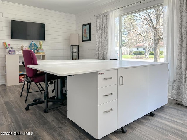 home office with wooden walls, dark wood-type flooring, and visible vents