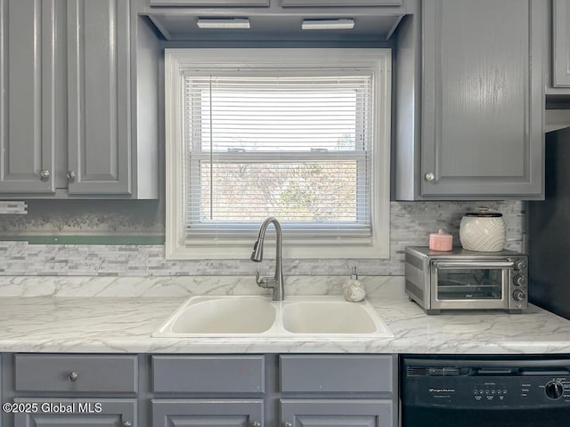kitchen with a sink, black dishwasher, gray cabinets, light countertops, and a toaster