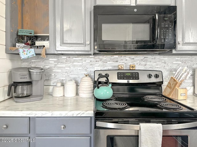kitchen with black microwave, stainless steel electric range oven, decorative backsplash, and gray cabinets