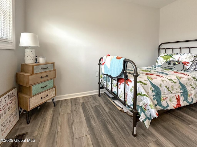 bedroom with baseboards and dark wood finished floors