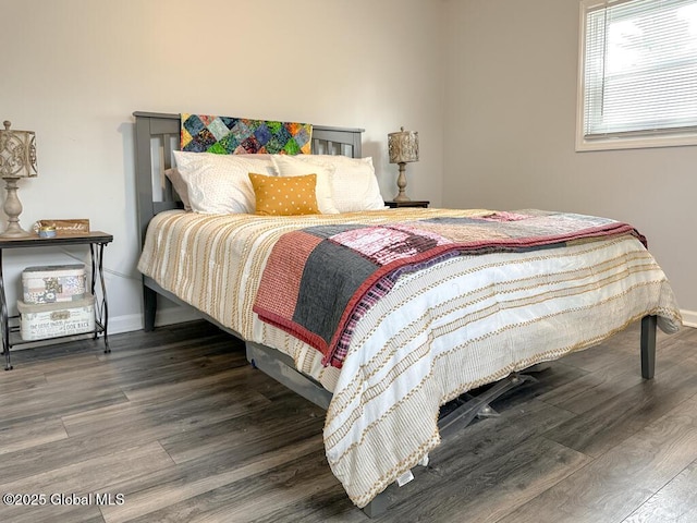 bedroom featuring wood finished floors and baseboards