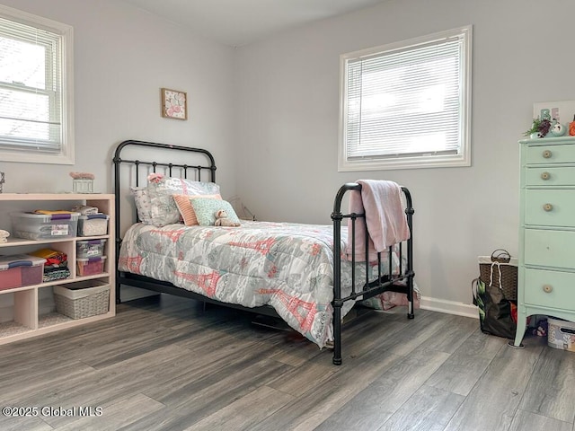 bedroom featuring wood finished floors and multiple windows