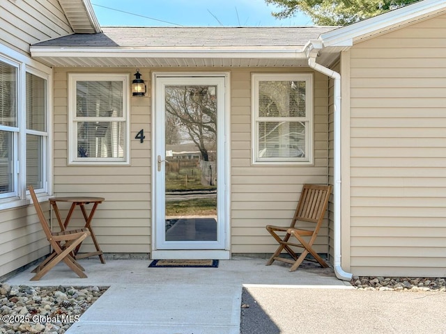 entrance to property featuring a shingled roof