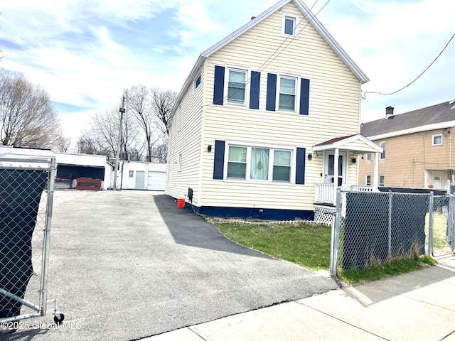 traditional-style home with a detached garage, an outbuilding, and fence