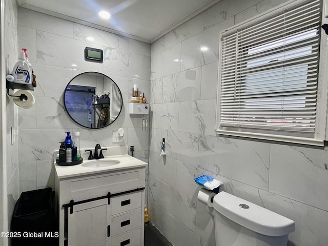half bathroom with toilet, vanity, and tile walls