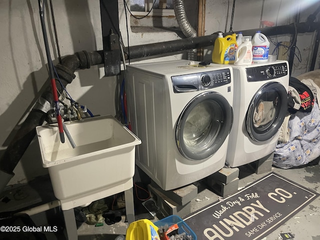 laundry area with washing machine and dryer, a sink, and laundry area