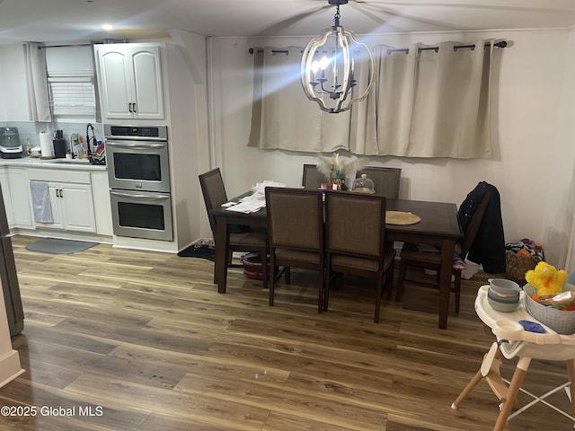 dining room with wood finished floors and an inviting chandelier