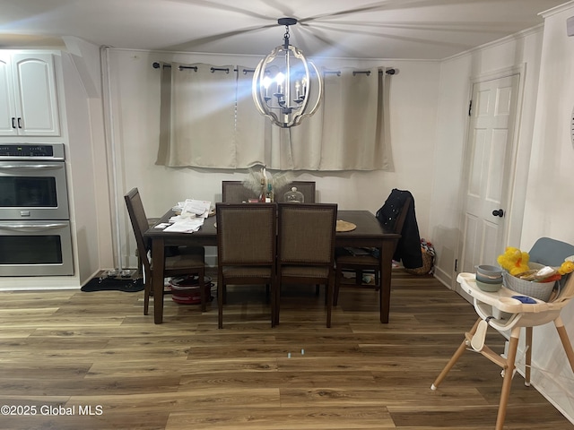 dining room with ornamental molding, a notable chandelier, and light wood finished floors
