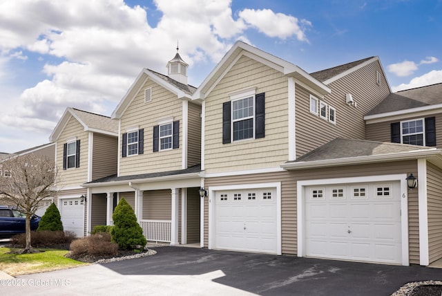 view of front of house featuring an attached garage, roof with shingles, and driveway