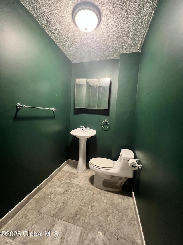 66 Jefferson St, Troy, NY 12180 - half bath featuring a textured ceiling, toilet, baseboards, and a sink