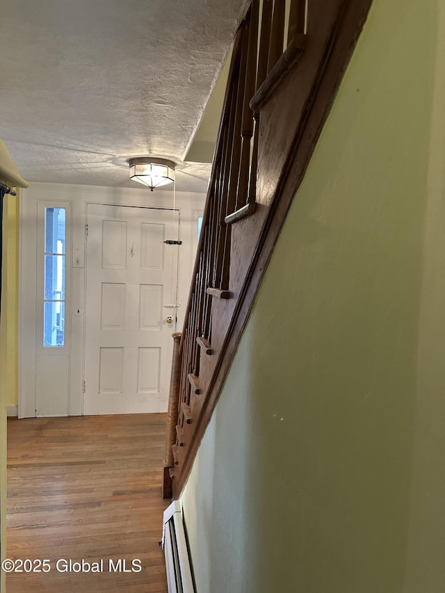 230 S Rd, Stephentown, NY 12018 - entrance foyer featuring wood finished floors, stairs, a textured ceiling, and a baseboard radiator