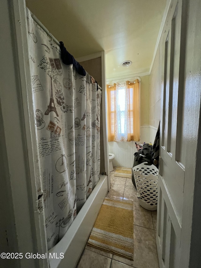 bathroom with tile patterned flooring, toilet, shower / bath combo, and ornamental molding
