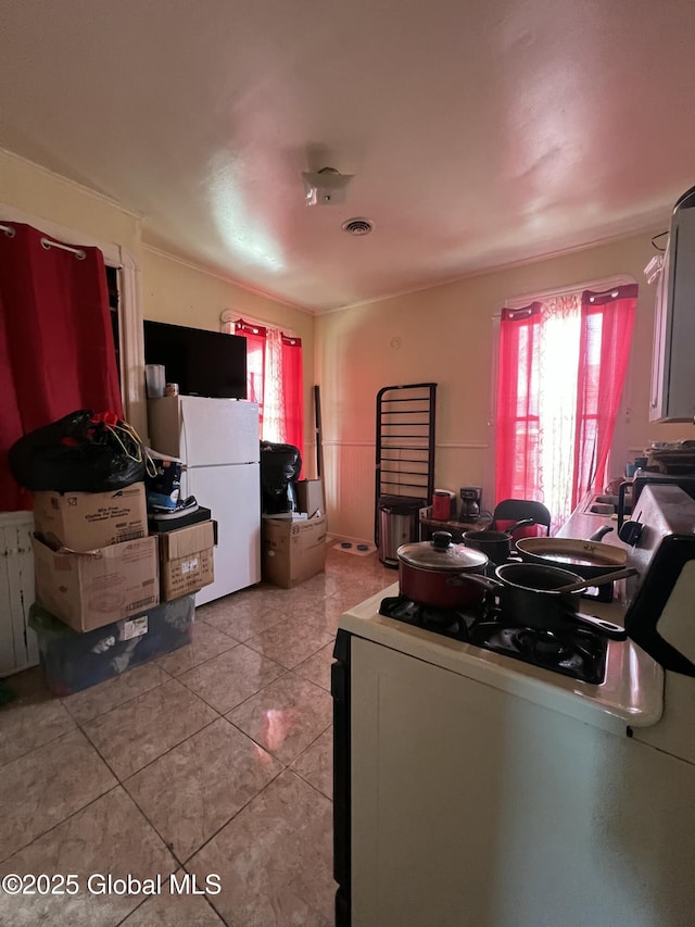 dining area with a wealth of natural light, light tile patterned flooring, and visible vents