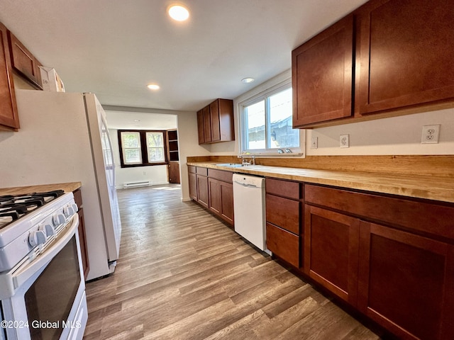 kitchen with plenty of natural light, recessed lighting, white appliances, and light wood-type flooring