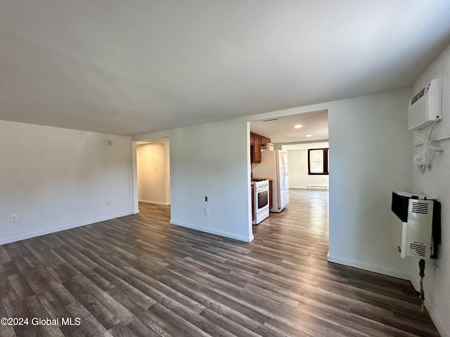 unfurnished living room with a wall mounted air conditioner, baseboards, dark wood-style flooring, and heating unit