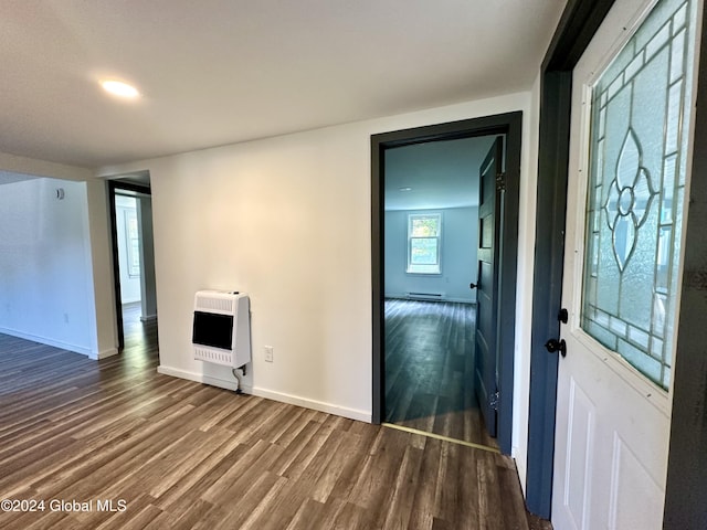 foyer entrance with baseboard heating, baseboards, wood finished floors, and heating unit