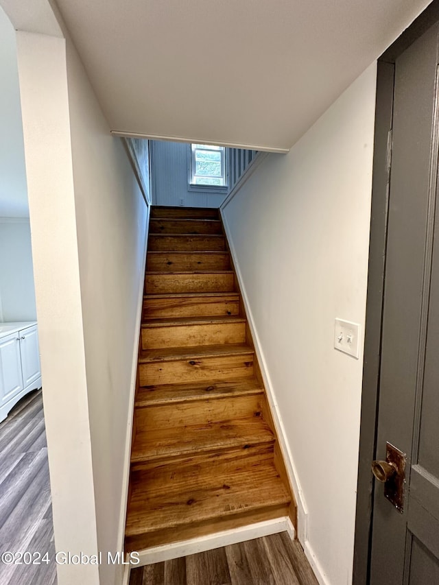 stairs with wood finished floors and baseboards