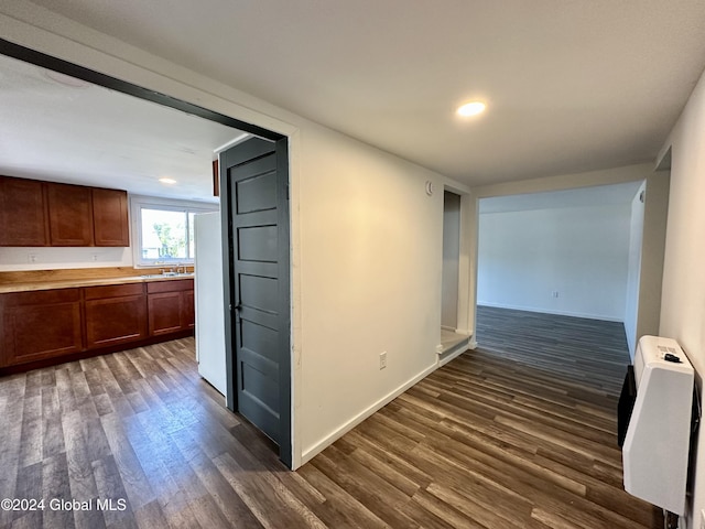 hall with baseboards, dark wood-style flooring, a sink, and recessed lighting