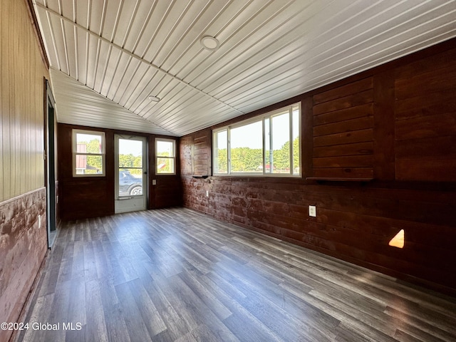 interior space with plenty of natural light, wood finished floors, wood walls, and vaulted ceiling