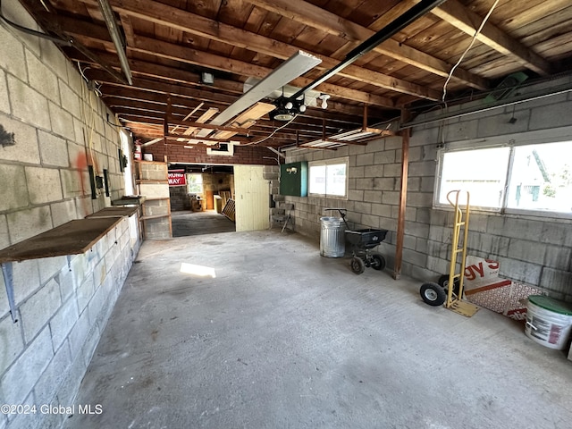 interior space featuring concrete flooring, concrete block wall, and a garage