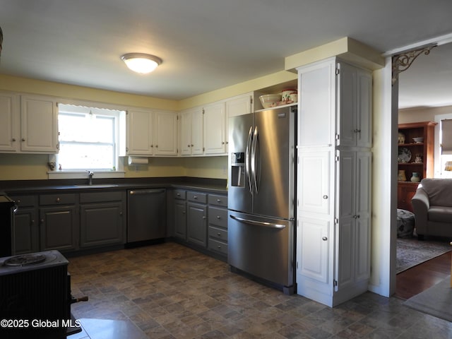 116 Dennie Rd, Mayfield, NY 12117 - kitchen with stainless steel appliances, dark countertops, stone finish flooring, and white cabinetry