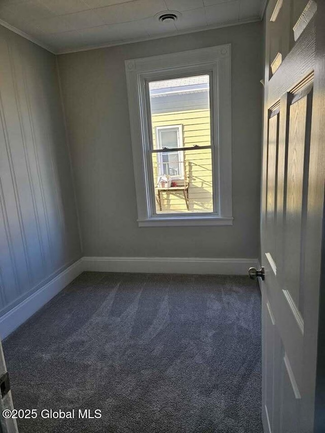 235 5th Ave, Troy, NY 12180 - spare room featuring dark carpet, baseboards, ornamental molding, and visible vents