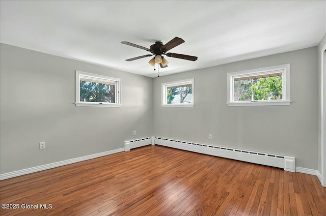empty room featuring baseboards, hardwood / wood-style floors, baseboard heating, and ceiling fan