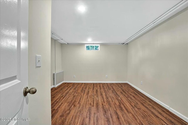 basement featuring baseboards and wood finished floors