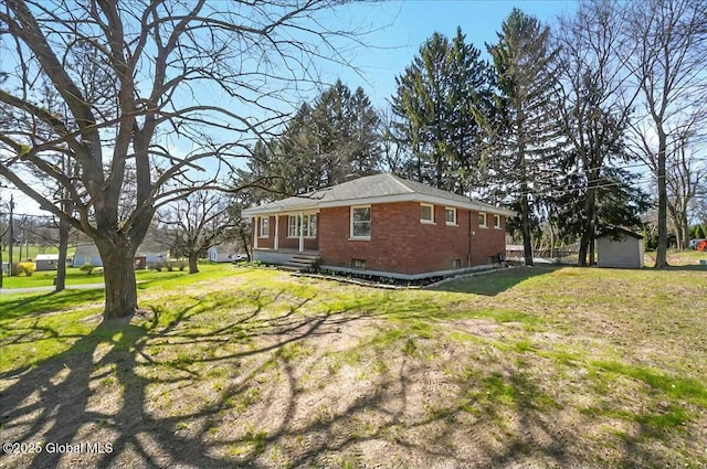 view of side of property with a lawn and brick siding