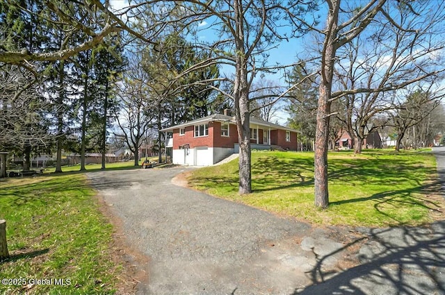 view of front of house with a garage, a front yard, and aphalt driveway