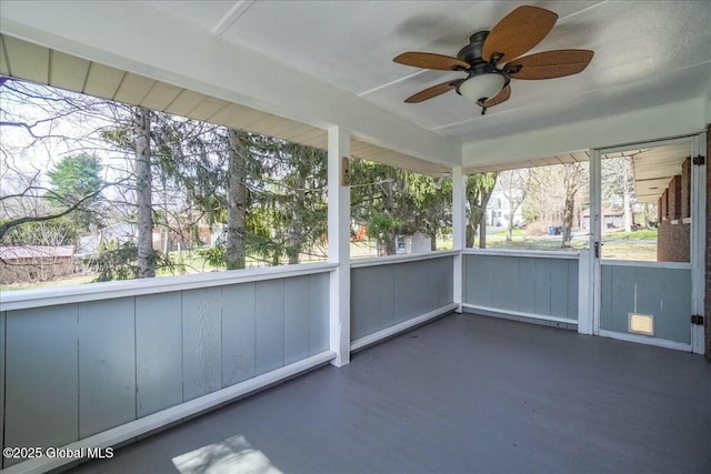 unfurnished sunroom featuring ceiling fan