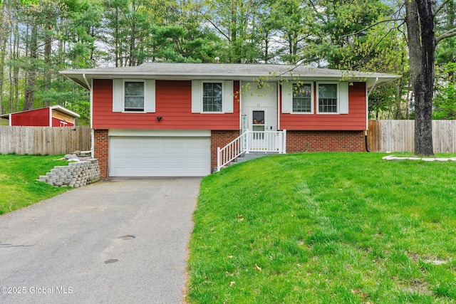 split foyer home with asphalt driveway, an attached garage, and brick siding