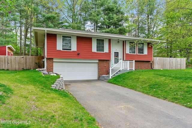 split foyer home with an attached garage, asphalt driveway, and brick siding