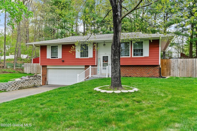 raised ranch with a garage, brick siding, and driveway
